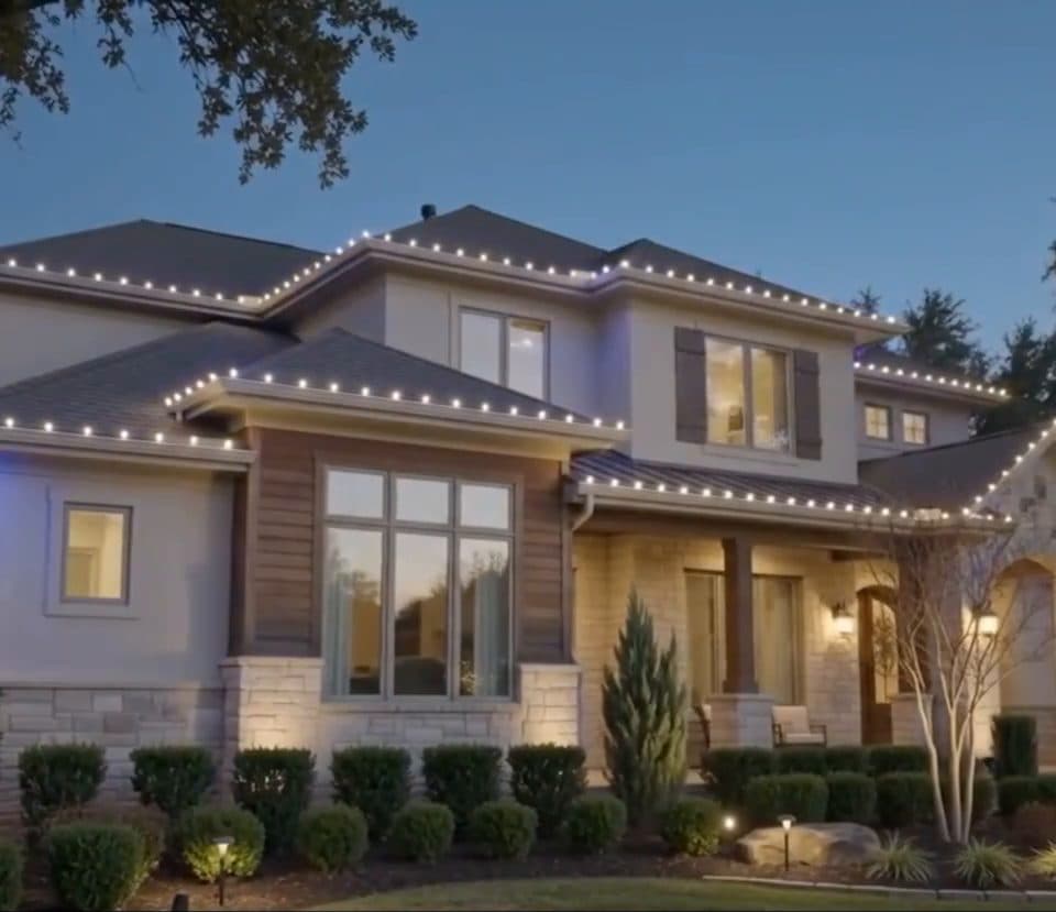 Two-story home at dusk, roofline traced in soft warm white